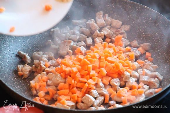 К мясу добавляем нарезанную кубиками морковь и обжариваем 2 минуты без крышки.