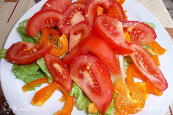Перец нарезать произвольно, помидор нарезать дольками. Выложить на лист салата, присыпать чесночным порошком.