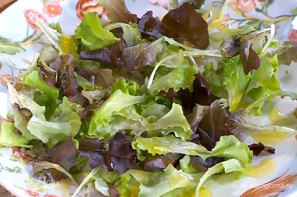 Листья салата выложить на блюдо и сбрызнуть оливковым маслом.