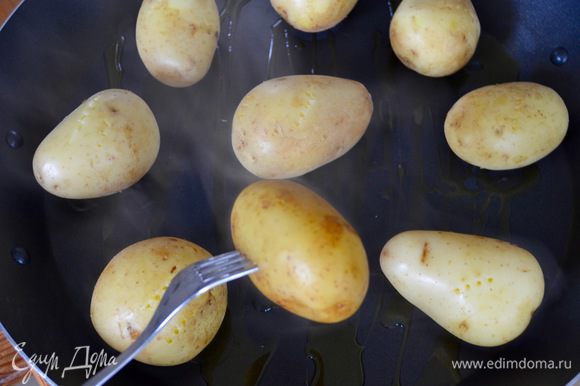 Поднос обильно сбрызнуть оливковым маслом и выложить картофель на небольшом расстоянии друг от друга.