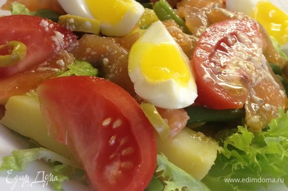 Собираем салат: на тарелку выкладываем листья салата, картофель, помидоры, стручковую фасоль, семгу, оливки. Сверху поливаем заправкой и красивенько выкладываем яйца.