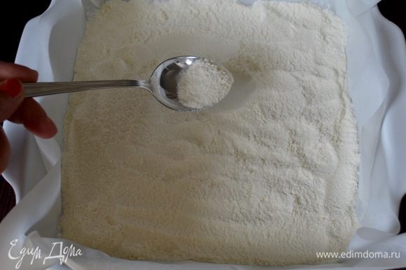 Форму размером 25х25 см проложить пекарской бумагой (или смазать немного маслом). Половину мучной смеси насыпать на дно формы, распределяя ровным слоем.