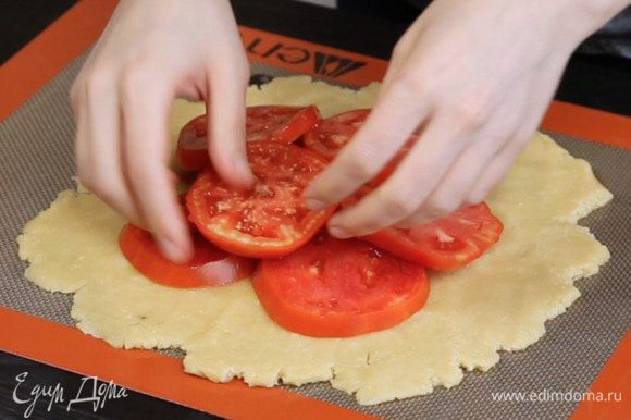 Раскатать тесто 4 мм толщиной, выложить в центр помидоры.