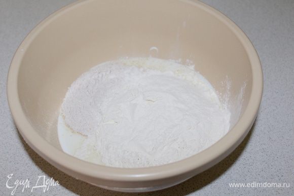 В миску налить кефир, добавить соль, сахар, соду, просеять обе муки.