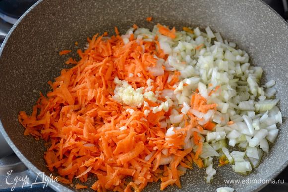 Овощи вымыть. Лук очистить и мелко нарезать, морковь натереть на крупной терке. В большой сковороде разогреть оливковое масло, добавить нарезанные овощи и измельченный зубчик чеснока. Пассеровать все пару минут до размягчения овощей.