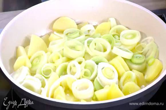 Разогреть в сковороде 2 ст. ложки оливкового масла и обжаривать картофель до появления золотистой корочки, а лук-порей до прозрачности.
