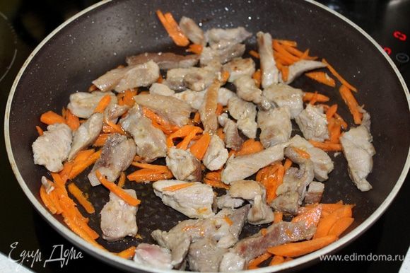 Обжарьте кусочки мяса на растительном масле, затем добавьте морковь соломкой, обжарьте 3-4 минуты.