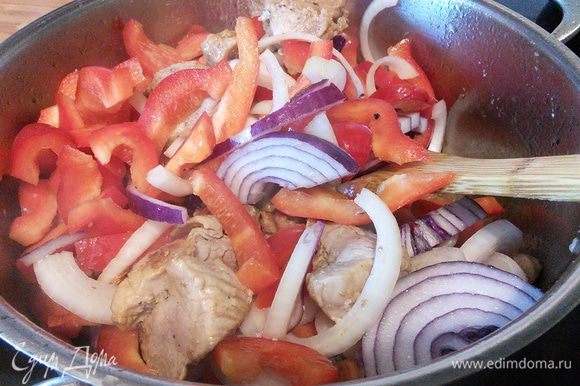 В глубокой сковороде или кастрюле разогреть масло и обжарить мясо в течении 3 минут. Добавить нарезанный полукольцами лук и перец, обжарить вместе с мясом.
