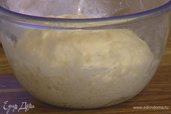 Приготовить тесто: добавить в опару теплое молоко, 2 ст. ложки оливкового масла, соль, 175 мл теплой воды, пшеничную муку и замесить, затем оставить на 2 часа в теплом месте.