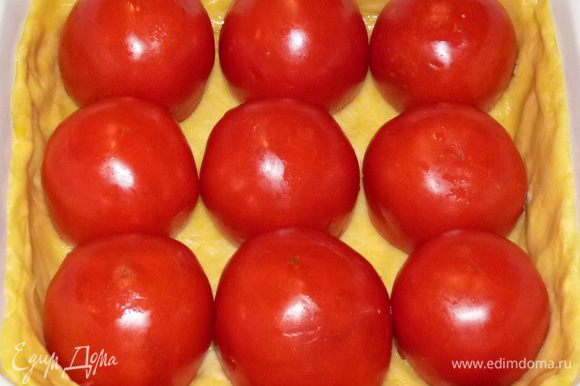Выложить на тесто фаршированные помидоры срезом вниз.