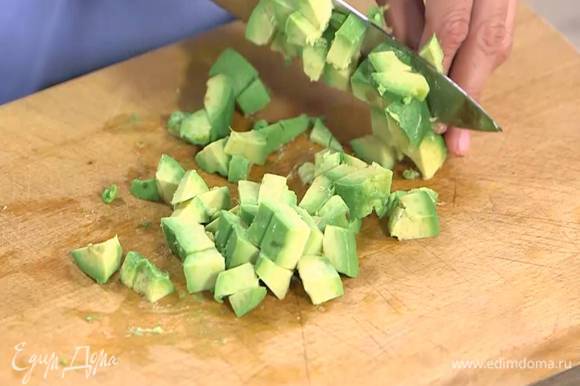 Авокадо разрезать пополам и, удалив кожуру и косточку, нарезать небольшими кубиками.
