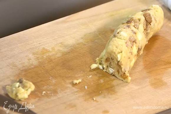 Сформировать из теста колбаску, затем нарезать ножом на небольшие лепешки и выложить на противень, выстеленный бумагой для выпечки.