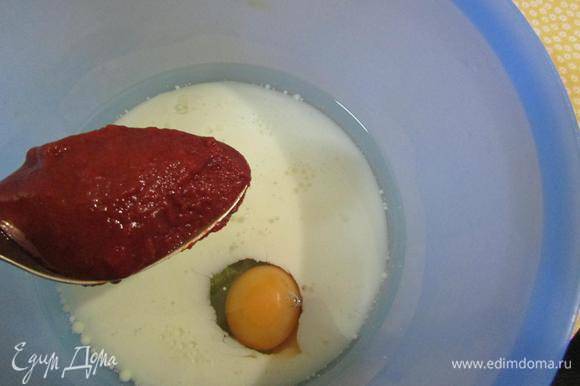 В миске соединить молоко, растительное масло и яйцо. Добавить томатную пасту и хорошо все перемешать.