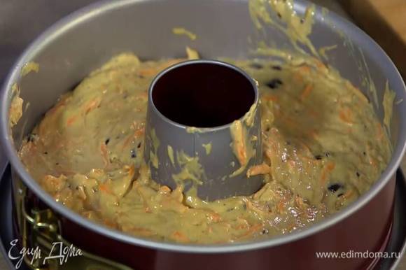 Разъемную форму для кекса с выемкой посередине смазать оставшимся оливковым маслом и равномерно выложить тесто.