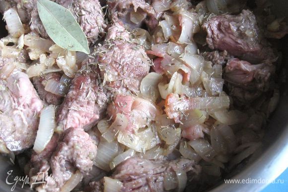 Переложить мясо из сковороды в теплоемкую кастрюлю с толстым дном. Посолить, поперчить, добавить тимьян, лавровый лист.