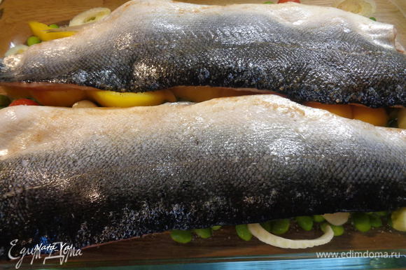 Выложить рыбу в форму поверх овощей, шкуркой вверх. И отправим в разогретую до 200°С духовку на 25 — 30 минут.