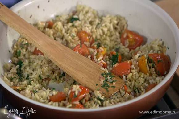К помидорам с луком и чесноком выложить отваренный рис, измельченную петрушку, все перемешать и немного прогреть.