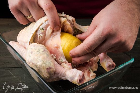 Делаем надрезы в лимоне и начиняем им курицу. Противень смазать частью растительного масла и уложить в него курицу.