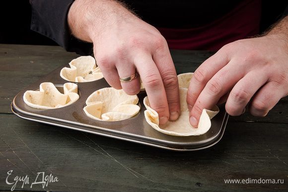 Тортилью с помощью формы нарезать кружочками. Поставить на 10 минут в разогретую до 170°С духовку .