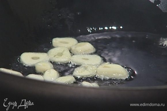В глубокой сковороде разогреть 3 ст. ложки оливкового масла и обжарить чеснок до прозрачности.