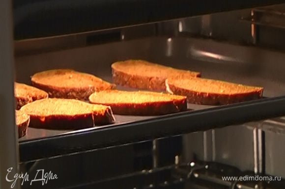 Приготовить брускетты: хлеб нарезать и запечь в духовке или поджарить в тостере, затем натереть оставшимся чесноком и сбрызнуть оливковым маслом.