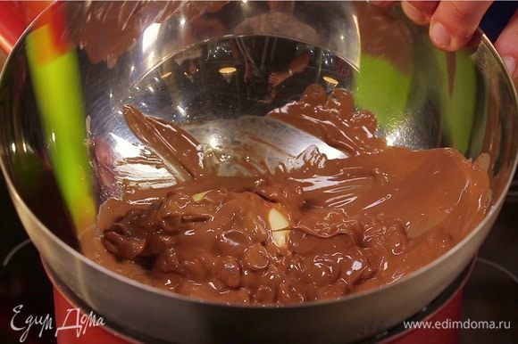 На водяной бане растопить 100 г сливочного масла и темный шоколад. Отставить в сторону. Добавить шоколад в яичную массу, добавить муку и разрыхлитель и перемешать.