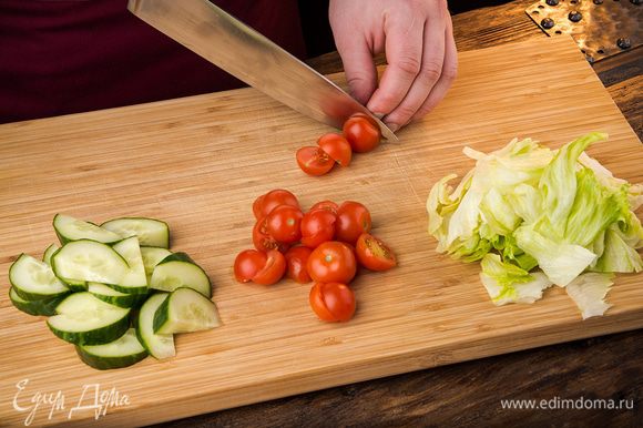 Нарезаем огурцы полукольцами, разрезаем пополам помидоры черри, салат айсберг режем произвольно.