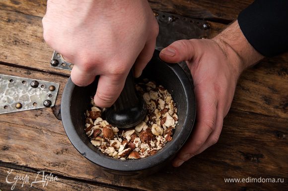 Очищенные орехи измельчите в ступке и перемешайте с полученным тестом.