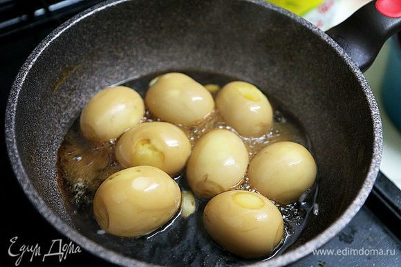 Уменьшить огонь и кипятить примерно 5 минут, постоянно переворачивая яйца, пока они не станут коричневыми, а соус не загустеет.