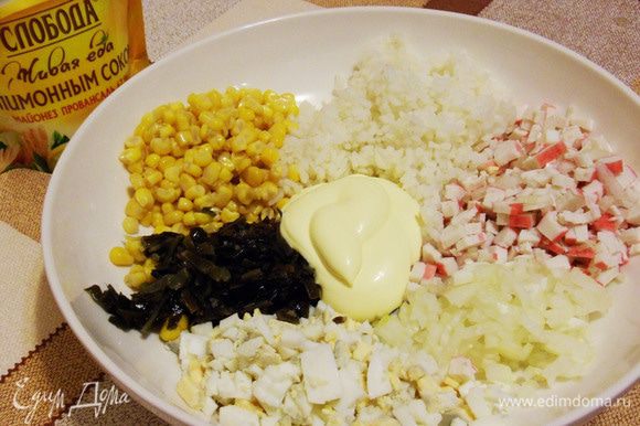 В миске смешать отварной рис, крабовые палочки, лук, яйца, консервированную сладкую кукурузу и морскую капусту. Добавить майонез.