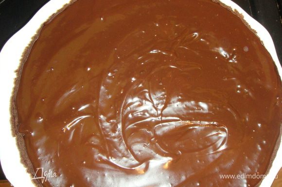 Выливаем шоколад на один корж и распределяем его по поверхности.