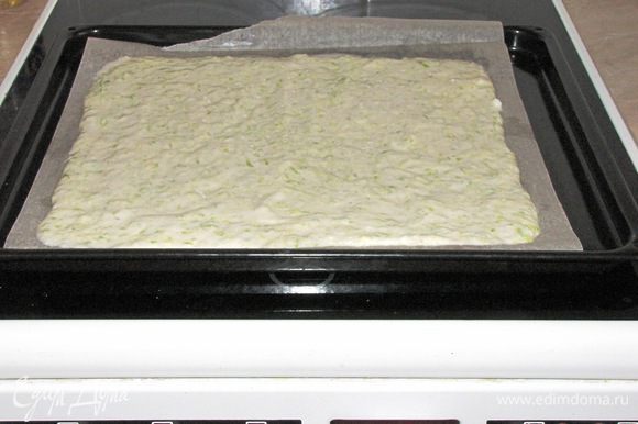 Противень застелить бумагой, смазать растительным маслом. Выложить тесто, распределить его в прямоугольник. Поставить в духовку, разогретую до 180°С, на 20 минут.