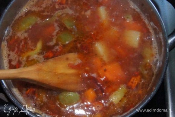 Острые овощи с томатом добавить к закипевшему картофелю. Посолить. Варить до готовности на среднем огне 15 минут. За 5 минут до готовности добавить измельченный чеснок и отваренный нут. Дать супу настояться минут 10 и подавать.