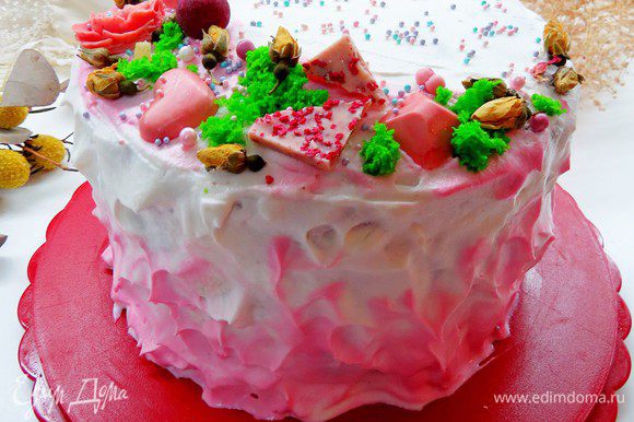 Для декорирования торта взбиваем 250 г сливок + 2 — 3 ст. л. пудры, 1/3 сливок откладываем и добавляем каплю розового красителя. Покрываем верх и бока тортика взбитыми сливками, низ и при желании верх тортика дополнительно оттеняем розовыми сливками.