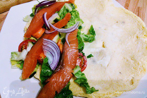 Выкладываем омлет на тарелку, на одну сторону выкладываем салат и кусочки лосося (рыбка тоже может быть любая).
