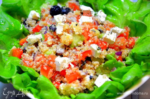 Разложить листья салата на тарелку, выложить сверху греческий салат с киноа, заправить соусом и подавать. Приятного и полезного ужина!