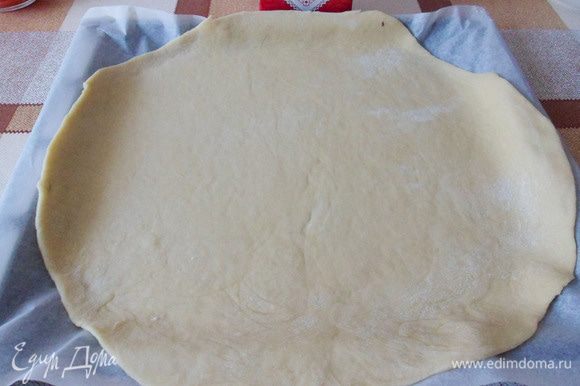 Раскатать в пласт толщиной около 0,6 см. Перенести раскатанное тесто на противень застеленный бумагой для выпечки.
