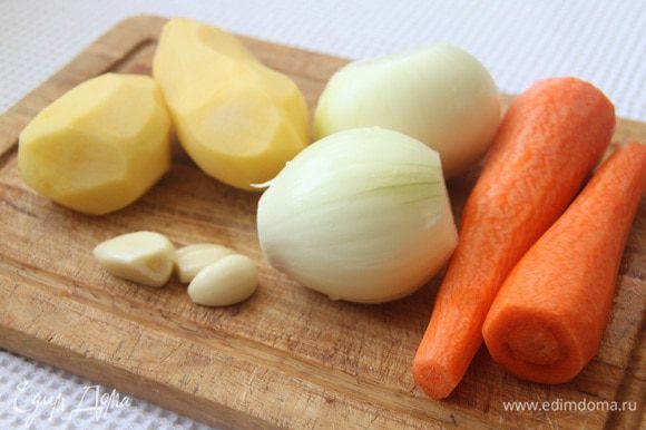 Подготовить овощи: почистить 2 моркови, 2 луковицы, 2 картофелины и 3 зубчика чеснока.