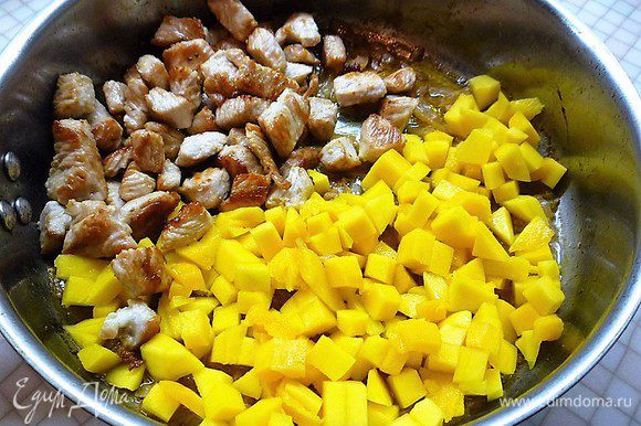 Выкладываем на сковороду мясо индейки и манго, тушим на слабом огне без крышки 3 минуты.
