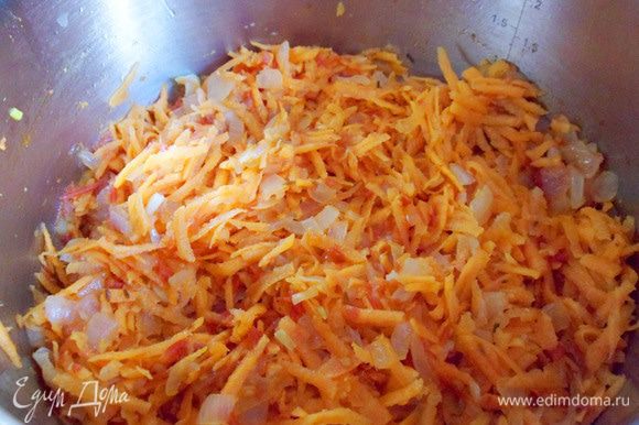 Добавить морковь, натертую на крупной терке. Перемешать и обжарить 2 — 3 минуты.