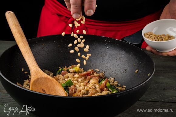 Выложить в сковороду бекон и рис, перемешать, добавить горчицу и кедровые орехи и еще раз все перемешать.