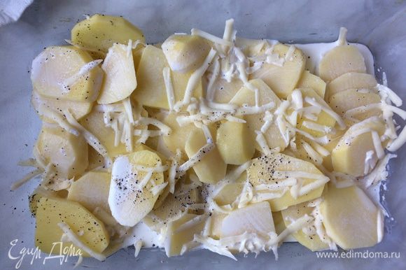 Форму для запекания смажьте оливковым маслом. Выложите картофель, посолите и поперчите. Добавьте 1/2 тертого сыра, залейте сливками и добавьте 1 ст. л. воды. Перемешайте и запекайте 25 минут. За 5 мин. до готовности посыпьте оставшимся сыром.