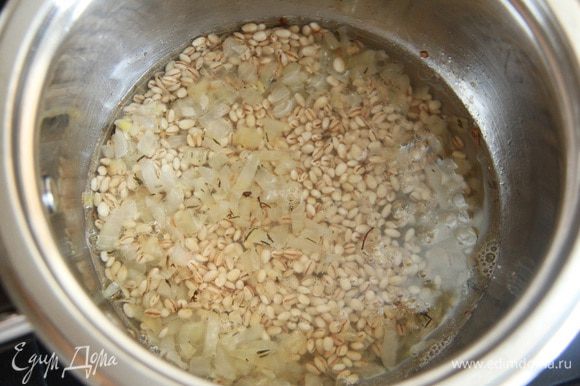 Промытую перловую крупу положить в кастрюлю к луку, добавить 2-3 половника овощного бульона. Варить на слабом огне до готовности (минут 20-25).