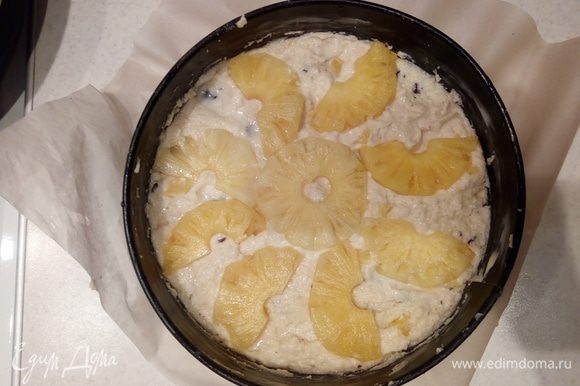 Сверху выложить веером половинки ананасовых колец, слегка вдавив их в тесто. Присыпать сверху сахарной пудрой. Отправить в предварительно разогретую до 170°С духовку на 50-55 минут.
