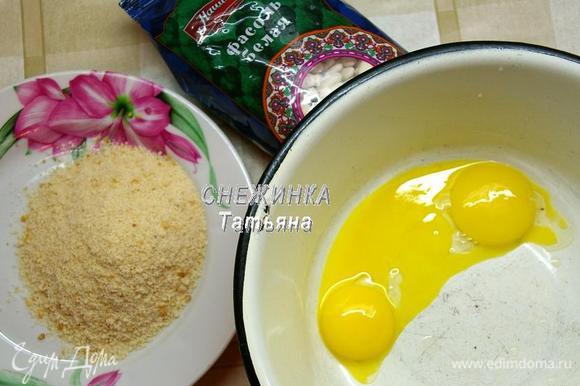 В это время отделяем желтки яиц от белков. Подготовим крошку белых сухарей. Я измельчила в кофемолке сухой белый батон. По желанию можно взять, к примеру, готовые ванильные сухари.