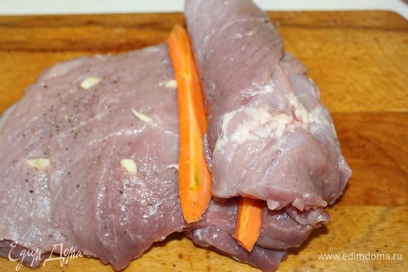 Закрутить мясо рулетом, вставляя полоски моркови. Посыпать немного мясо розмарином и тимьяном.