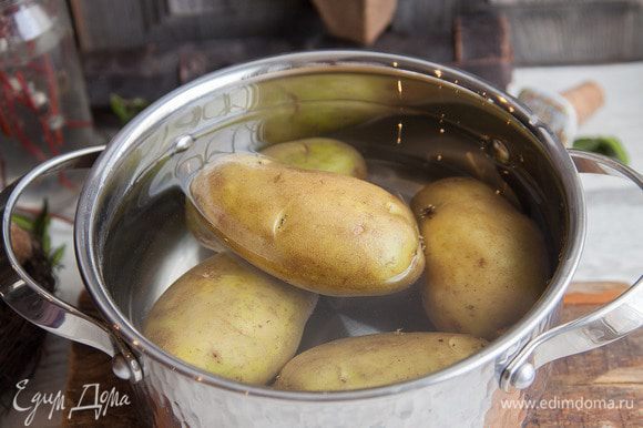 Моем и отвариваем в подсоленной воде картофель. Нарезаем остывший картофель на дольки.