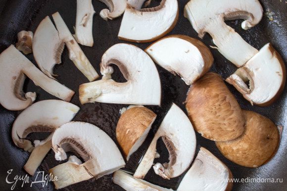 В сковороде разогреть оливковое масло, уложить в один слой вымытые порезанные грибы и обжарить на среднем огне. Грибы при жарке часто мешать не стоит. Поджарить с одной стороны, встряхнуть сковороду пару раз, чтобы грибы перевернулись и снова обжарить их до золотистого цвета. За время обжарки встряхивать сковороду 2-4 раза, не больше. Если грибов оказалось больше, чем уместилось в один слой на сковороде, то ображарить их в несколько этапов, не нужно все грибы выкладывать на сковороду сразу. Нужно чтобы грибы не томились на сковороде, а именно обжарились с двух сторон, приобрели хрустящую корочку, а внутри остались мягкими и не потеряли влагу.