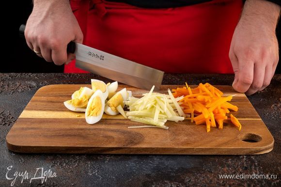 Отварите морковь и яйца. Нарежьте соломкой морковь, очищенные огурцы и яйца.