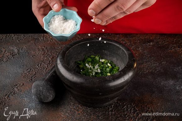 Измельчите зеленый лук и протрите с солью.